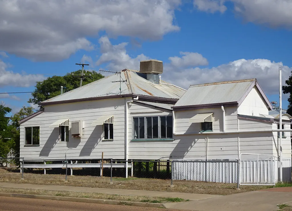 Weatherboard Queenslander on stilts with a wide front verandah in afternoon light
