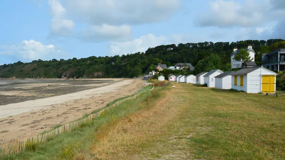 Fibro beach cottage behind a low timber fence on a coastal street
