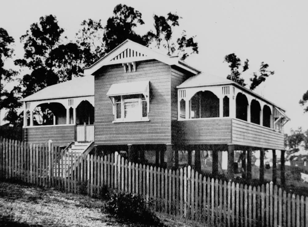 Raised timber Queenslander with a wide verandah and corrugated iron roof in morning sun