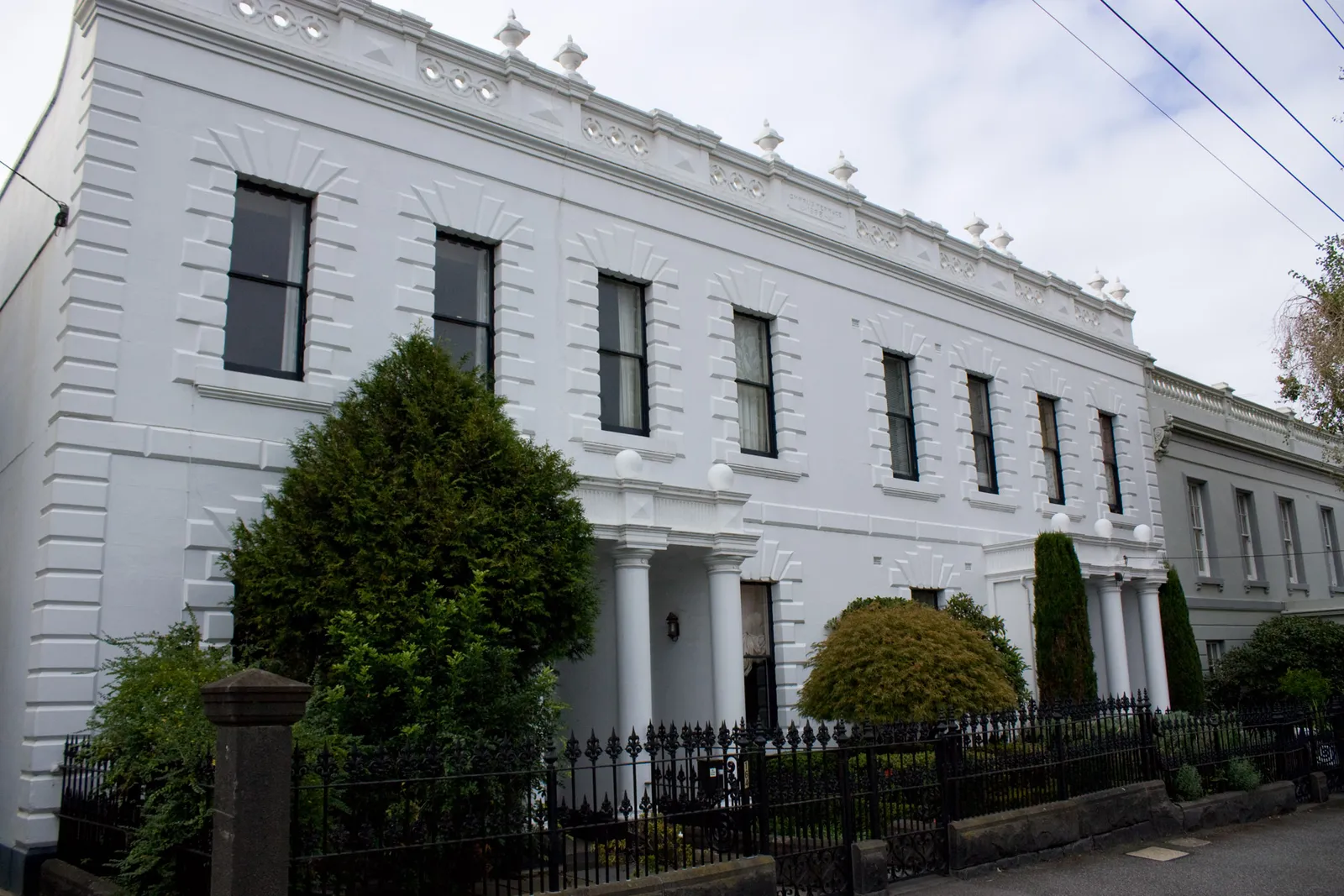 Row of Victorian terrace houses with iron lace balconies on an inner Melbourne street